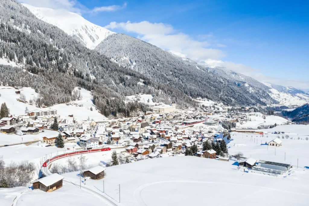 Eine Luftaufnahme einer kleinen Stadt in den Alpen mit wunderschöner Umgebung.