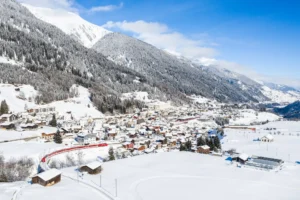 Eine Luftaufnahme einer kleinen Stadt in den Alpen mit wunderschöner Umgebung.