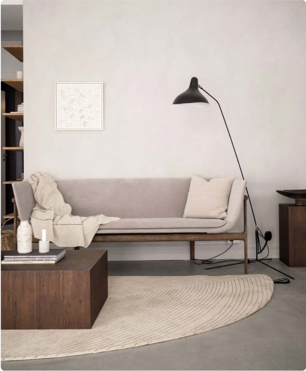 A living room with a sofa, coffee table and lamp, perfect for your home project.